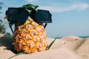 pineapple wearing sunglasses at beach