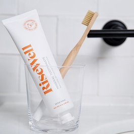 glass with tube of risewell toothpaste toothbrush